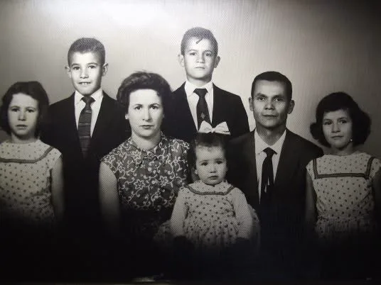 Retrato antigo de família com sete pessoas, desgastado pelo tempo, antes da restauração.